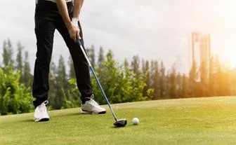 Golfer addressing the ball on a sunlit fairway