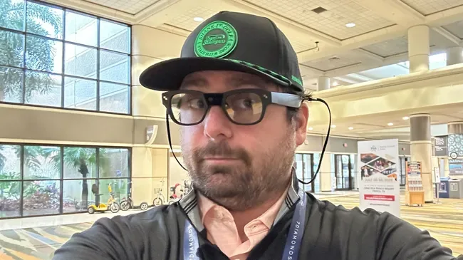 Founder Jason Schneider wearing CaddieVision glasses at a trade show