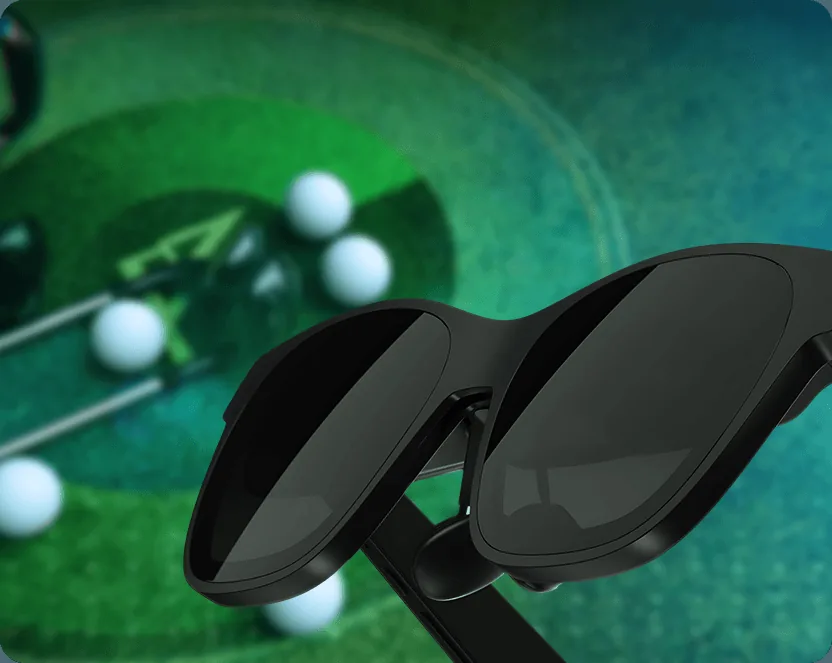 CaddieVision glasses resting on a putting green with golf balls