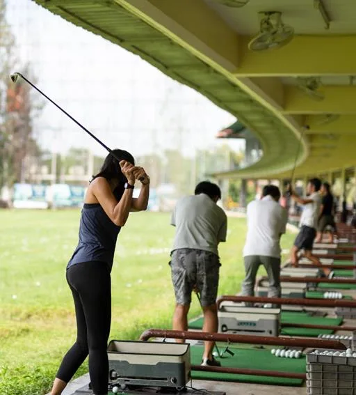 Golfers practicing at a covered driving range